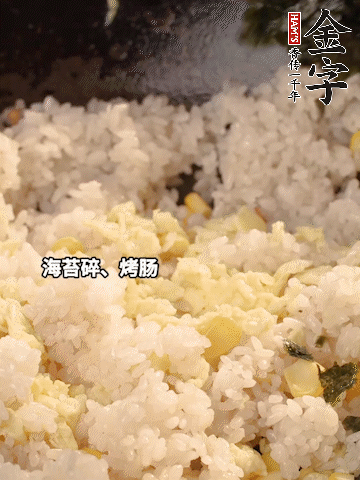 剩米飯下鍋炒散，依次下玉米粒、雞蛋、烤腸、海苔碎翻炒均勻。
