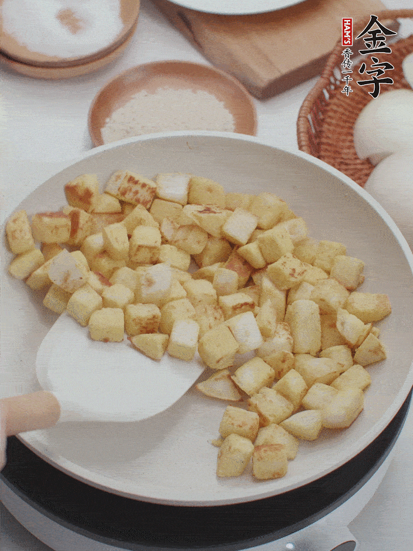 起鍋熱油，倒入饅頭丁，小火煎至蛋液凝固定型再翻面，饅頭丁部煎至金黃時盛起待用。