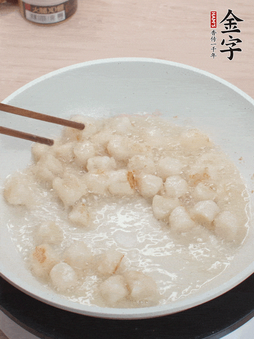 油溫4成熱，鮮貝蘸干淀粉下鍋煎，一面微黃后翻面。