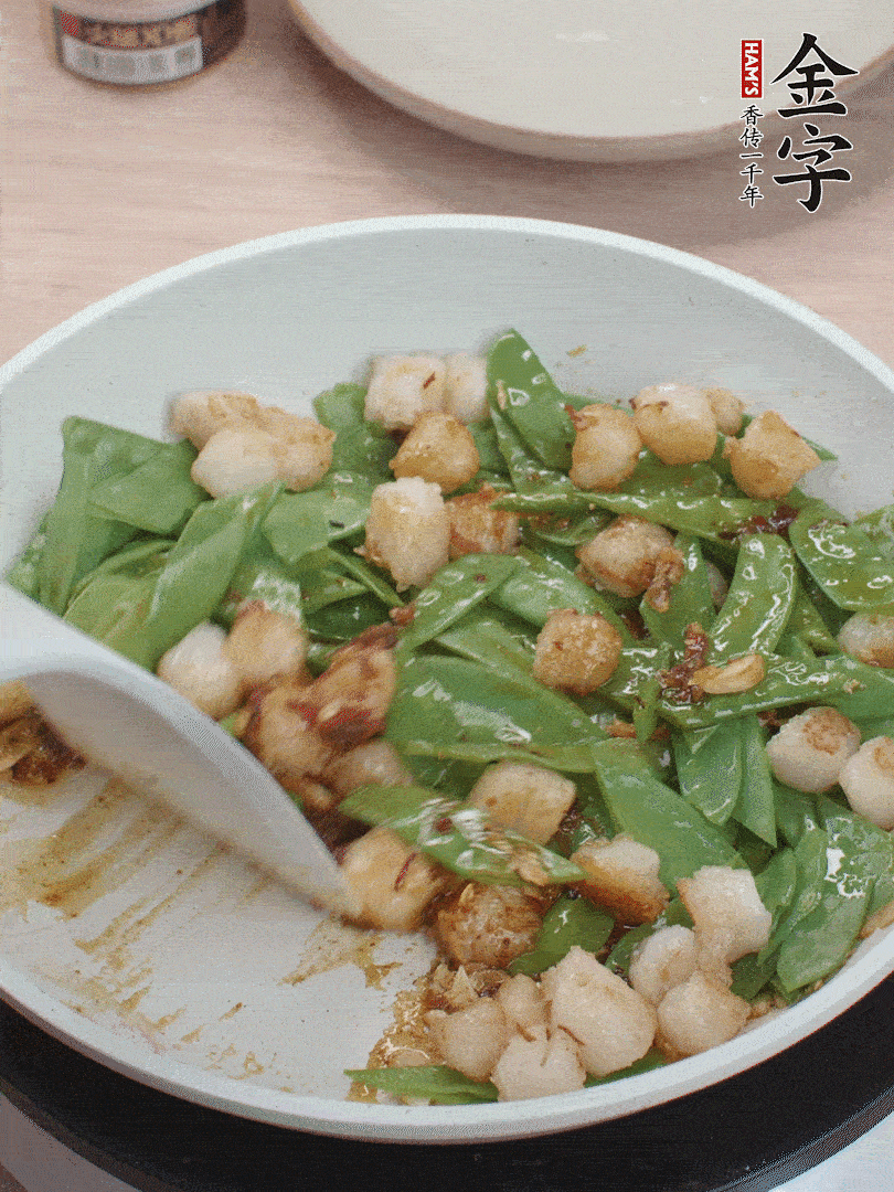 下甜豆莢、鮮貝輕輕翻炒均勻。