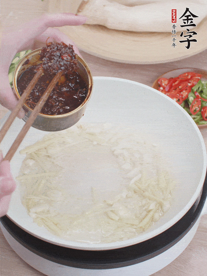 起鍋熱油，姜蒜、金字火腿干貝醬煸香。