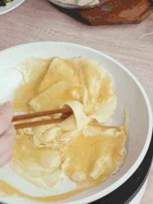油6成熱時，下雞蛋液，邊緣凝固時翻拌成塊狀。