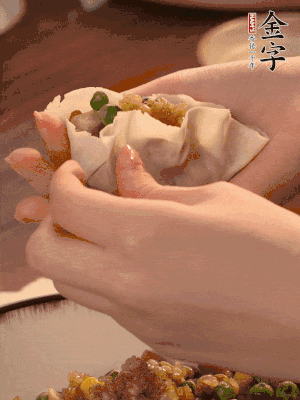 取一大勺餡料放進(jìn)餃子皮里，用大拇指按住頂部餡料，再用虎口掐出形狀。