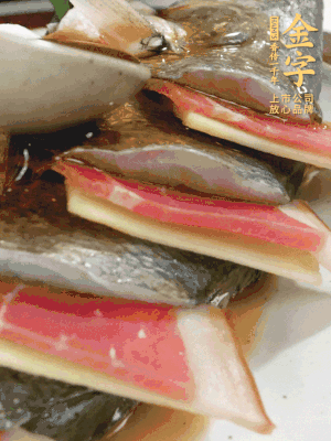 魚肚中塞蔥結(jié)、火腿片，魚身上碼放姜片、火腿片，倒入混合的料汁。