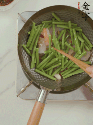 下掰好的缸豆段翻炒，略燜煮。