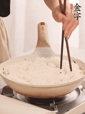 把瀝干水分的米飯均勻鋪在上面，筷子戳幾個洞，以便透氣，轉(zhuǎn)小火蓋上蓋子燜至水分收干，大概10分鐘。